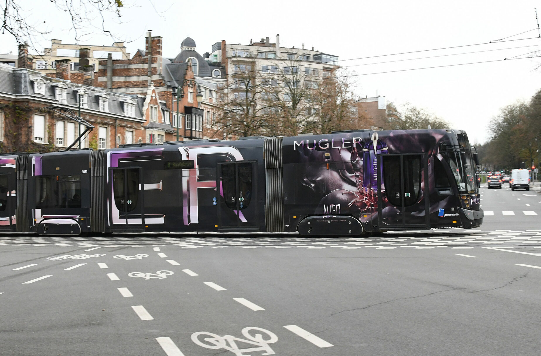 Brusselse tram volledig bedekt met een parfumcampagne in zwart en paars